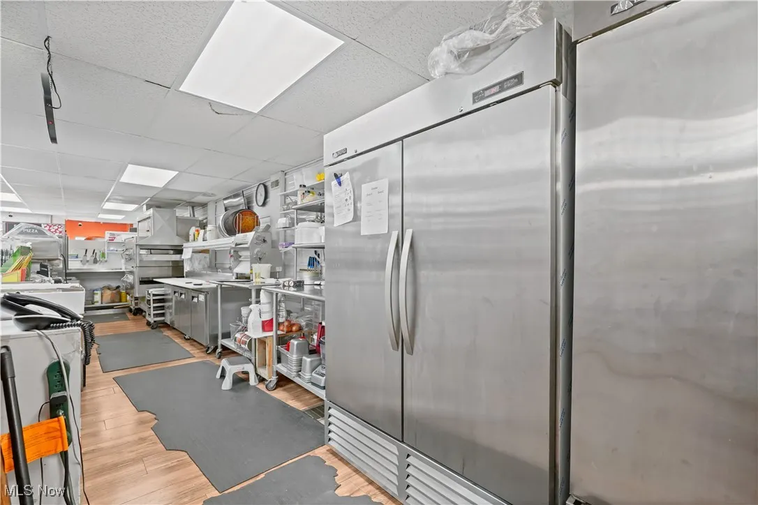 Kitchen featuring a paneled ceiling, stainless steel refrigerator, and freestanding refrigerator