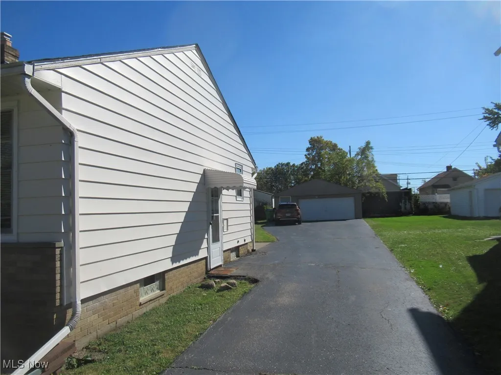 View of home's exterior featuring an outdoor structure, a yard, and a garage