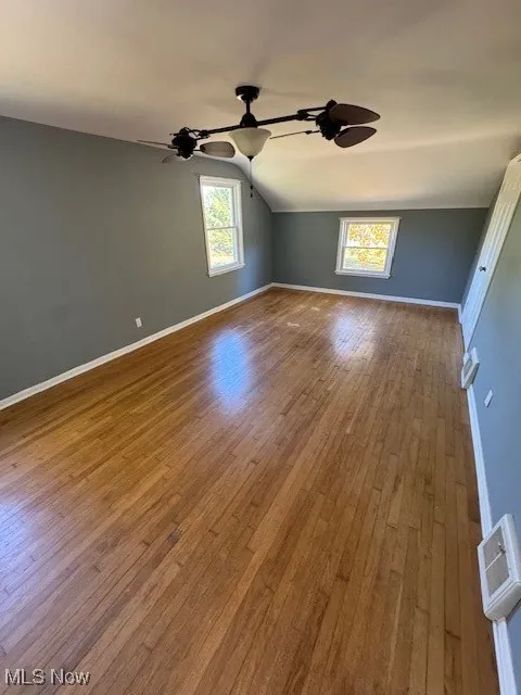 Empty room featuring hardwood / wood-style floors and lofted ceiling