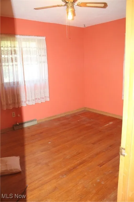 Empty room with light wood finished floors and a ceiling fan