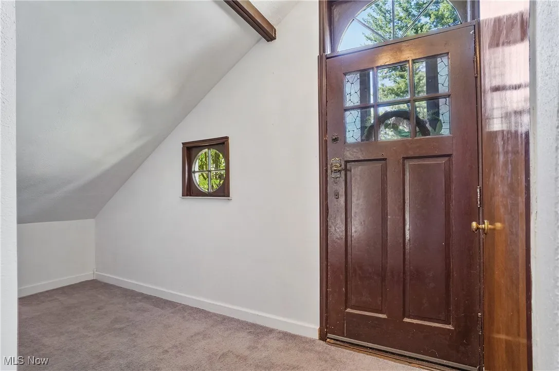 Foyer with light carpet and baseboards