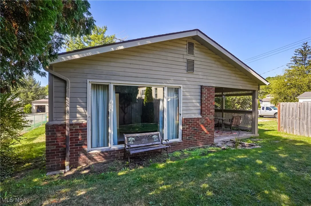 Back of house with brick siding and a patio