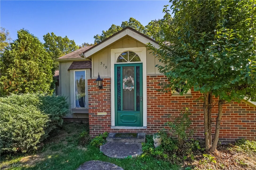 Doorway to property featuring brick siding