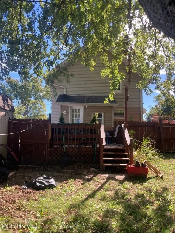 Rear view of property featuring a fenced backyard, a wooden deck, and a gate