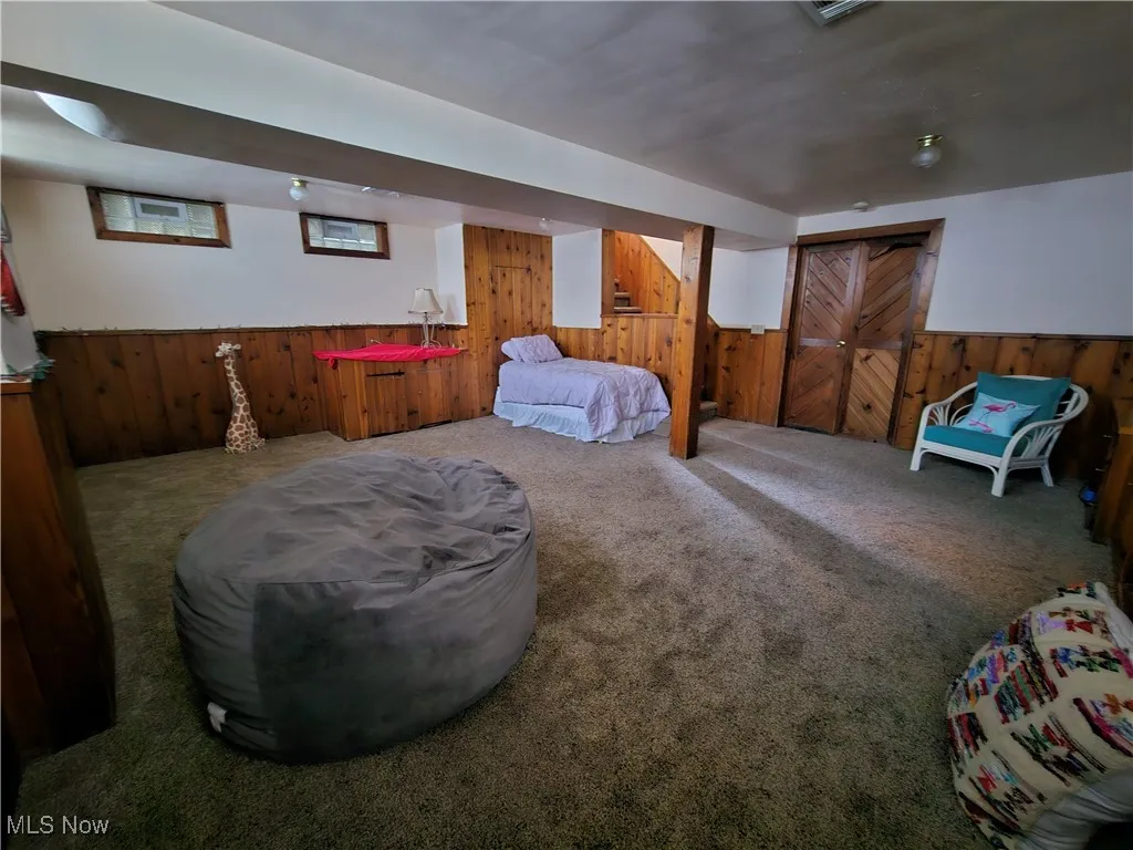 Carpeted bedroom with wooden walls