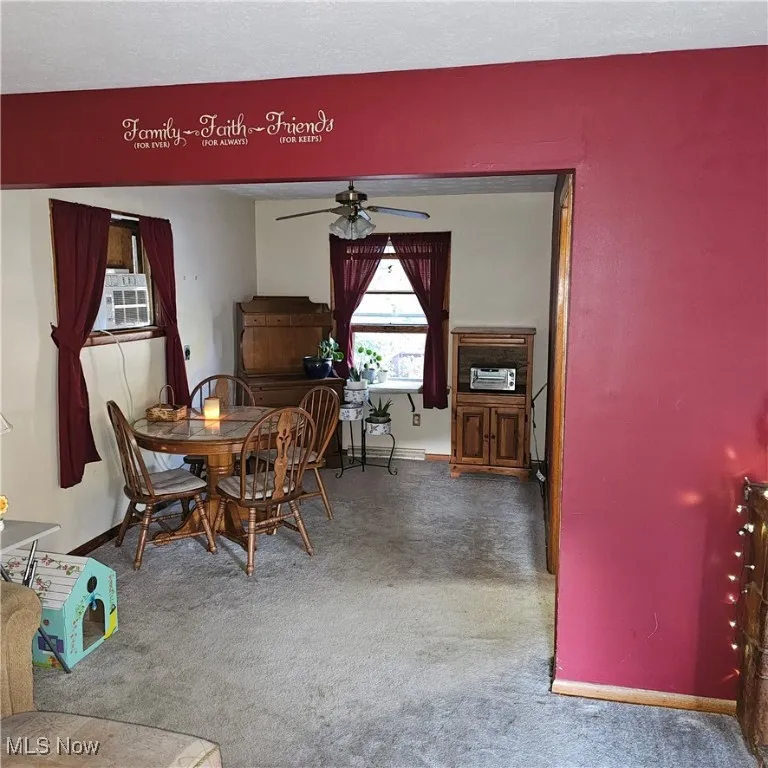 Dining room featuring carpet flooring, a ceiling fan, and a baseboard heating unit
