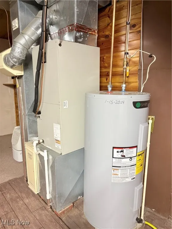 Utility room featuring water heater and heating unit