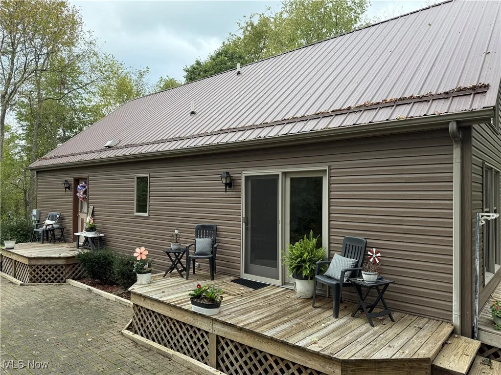 Back of house with a deck and a metal roof