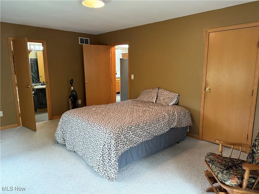 Carpeted bedroom with ensuite bathroom