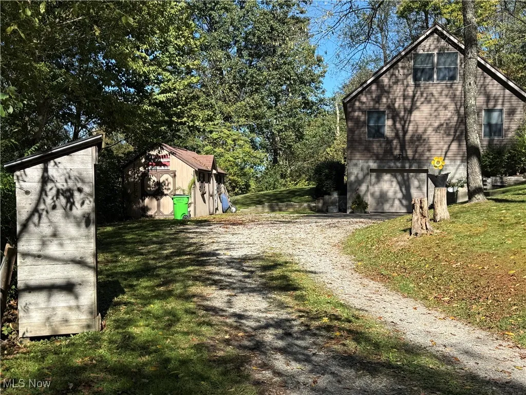 View of home's exterior featuring driveway, a lawn, and an attached garage