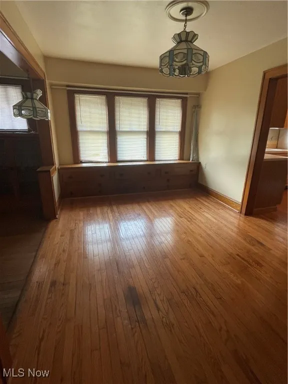 Unfurnished dining area featuring hardwood / wood-style flooring and plenty of natural light