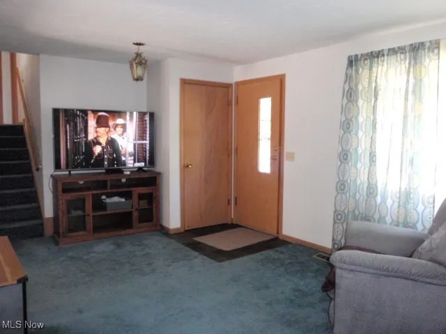Living area featuring carpet floors and stairs