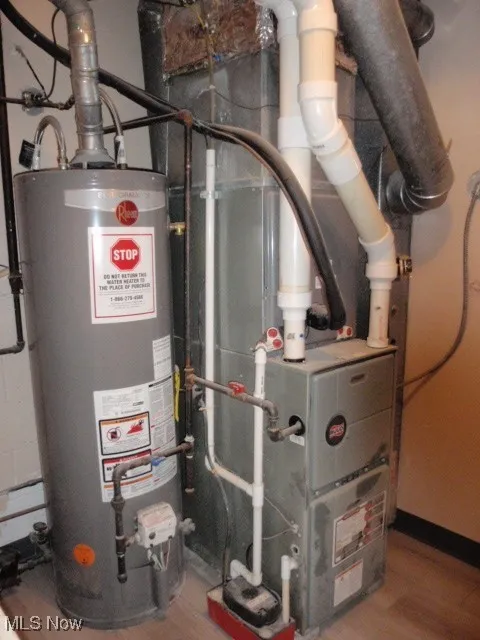 Utility room featuring gas water heater and heating unit