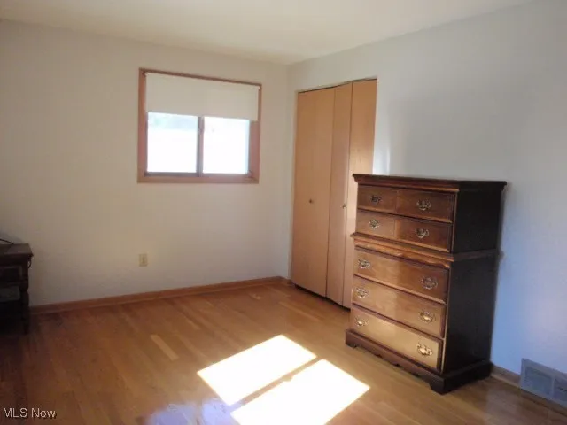Bedroom featuring light wood-style floors and a closet