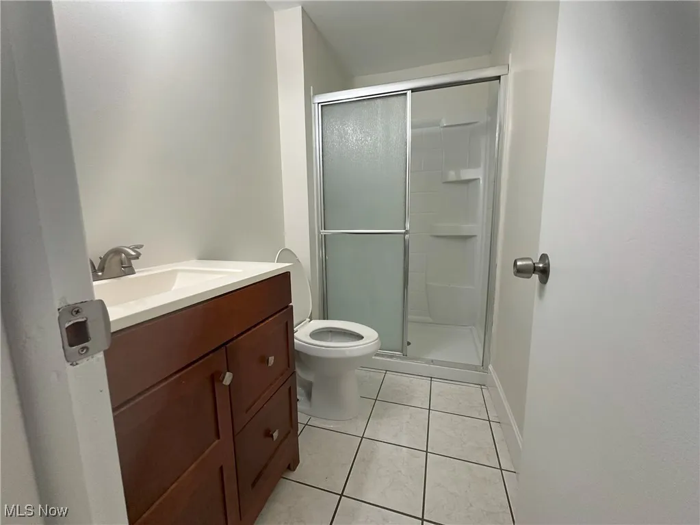 Bathroom featuring vanity, a shower stall, and light tile patterned flooring