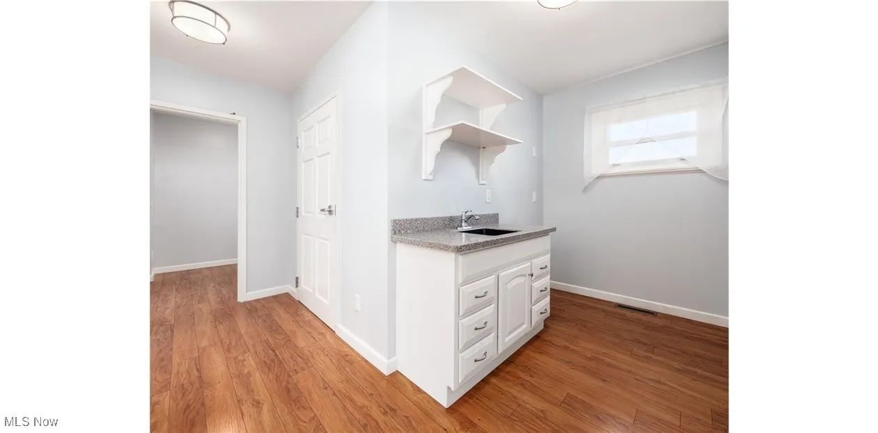Corridor featuring baseboards and light wood-style floors