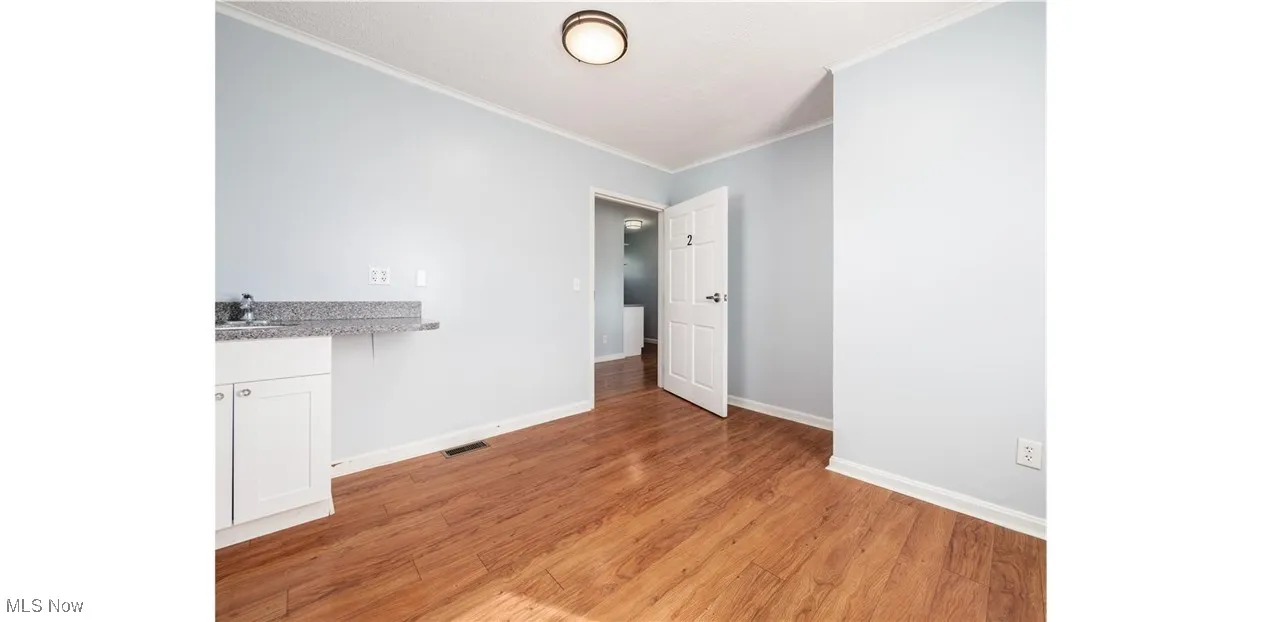 Unfurnished dining area featuring light wood-style floors and ornamental molding