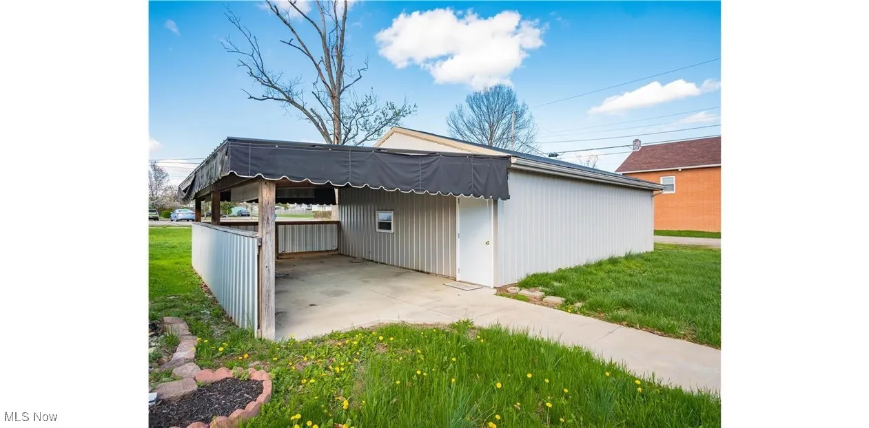 View of outbuilding with a carport and driveway