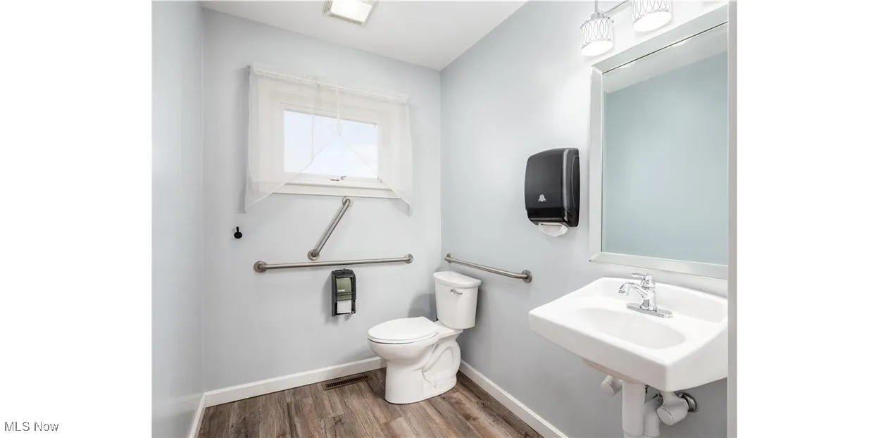 Bathroom featuring baseboards and dark wood-style floors