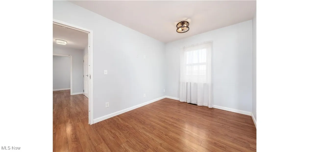 Spare room featuring wood finished floors and baseboards