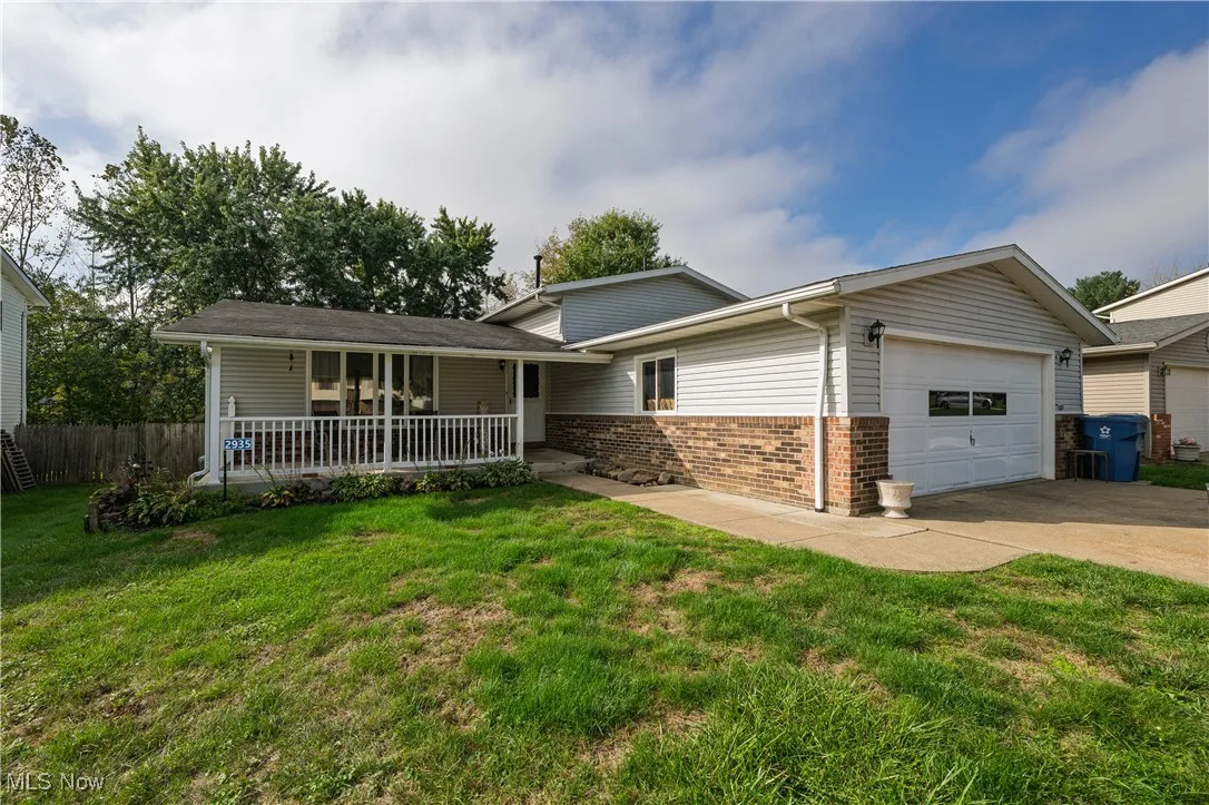 Split level home featuring brick siding, driveway, and an attached garage
