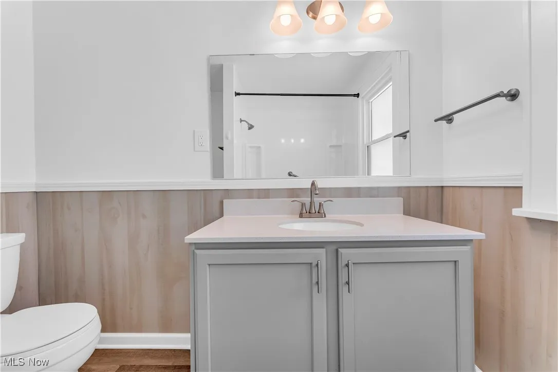 Bathroom with vanity and a wainscoted wall