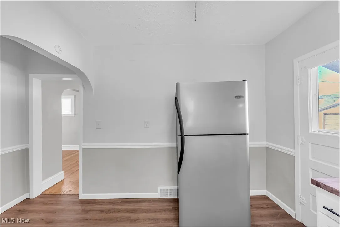 Kitchen featuring freestanding refrigerator, wood finished floors, and plenty of natural light
