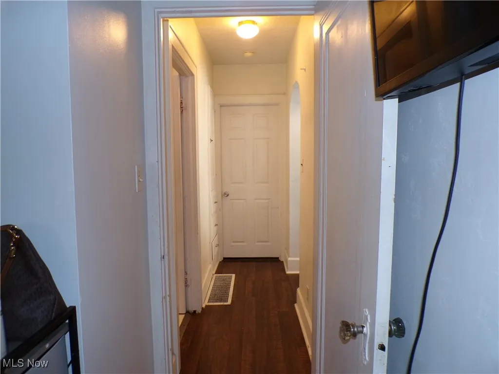 Hall featuring dark wood-style flooring and arched walkways