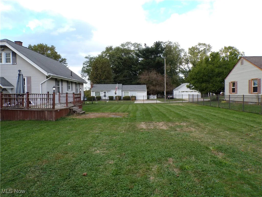 Fenced side/back yard featuring a wooden deck