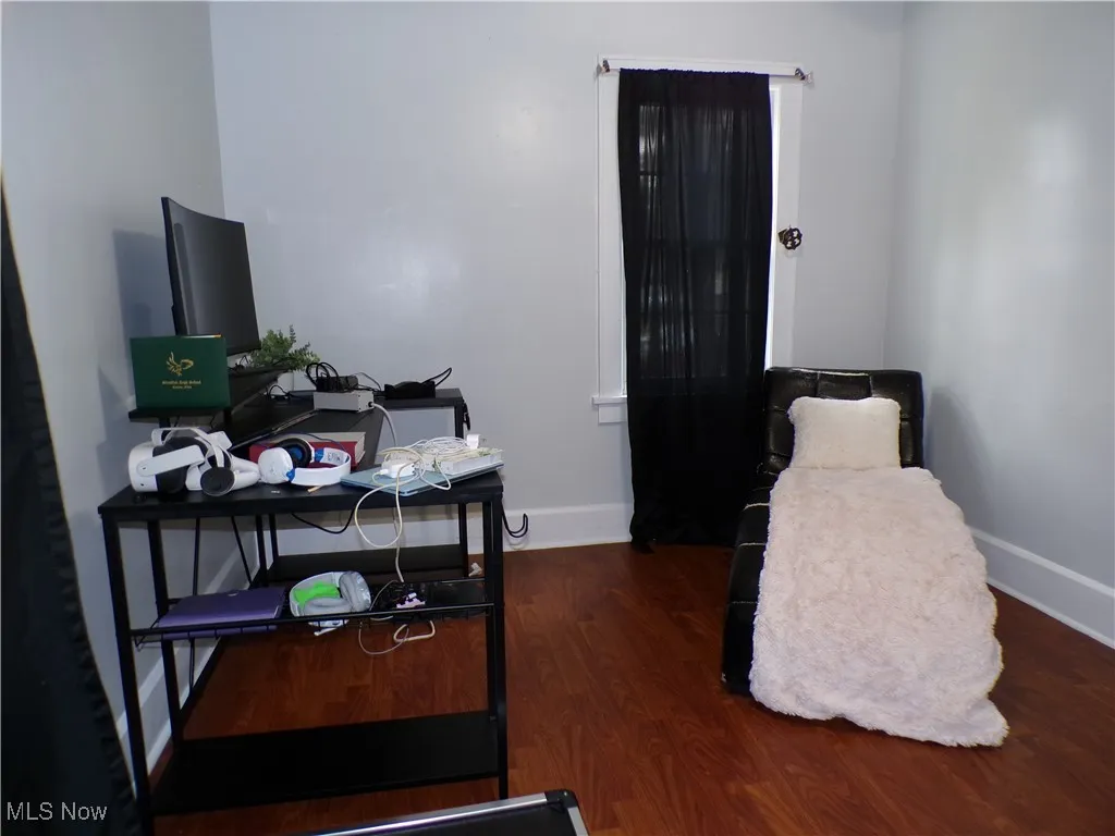Bedroom #2 with dark wood-style floors and baseboards
