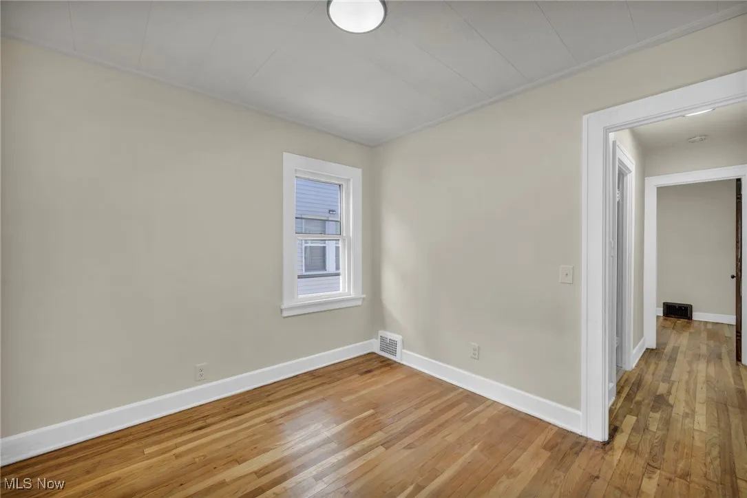 Unfurnished room with light wood finished floors and crown molding