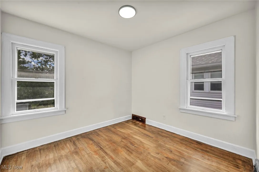 Empty room with baseboards and wood finished floors