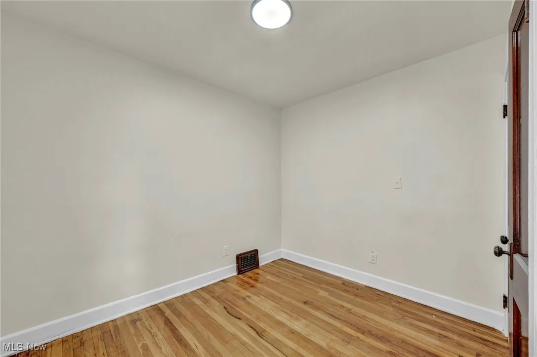 Empty room with baseboards and hardwood / wood-style flooring