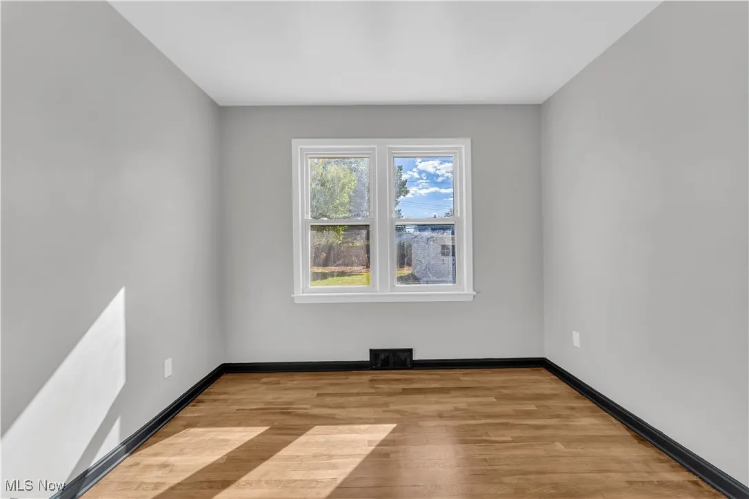 Unfurnished room with light wood-style floors and baseboards