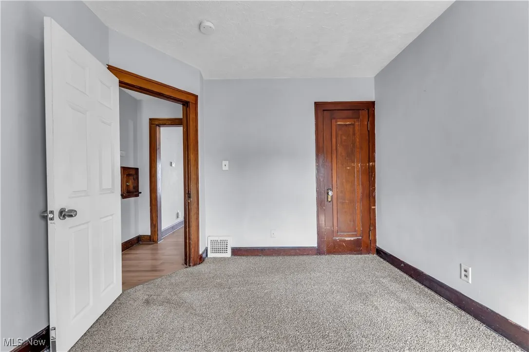 Carpeted spare room featuring a textured ceiling