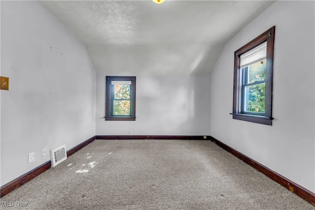 Bonus room featuring lofted ceiling, carpet flooring, healthy amount of natural light, and a textured ceiling