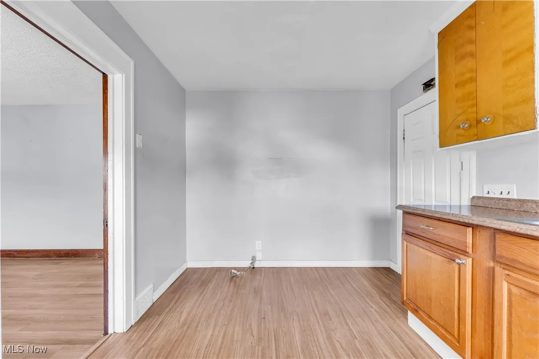 Unfurnished dining area with baseboards and light wood finished floors