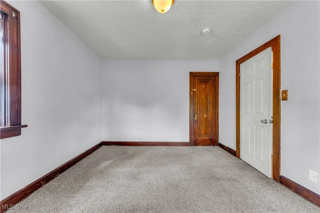 Empty room with carpet flooring and a textured ceiling