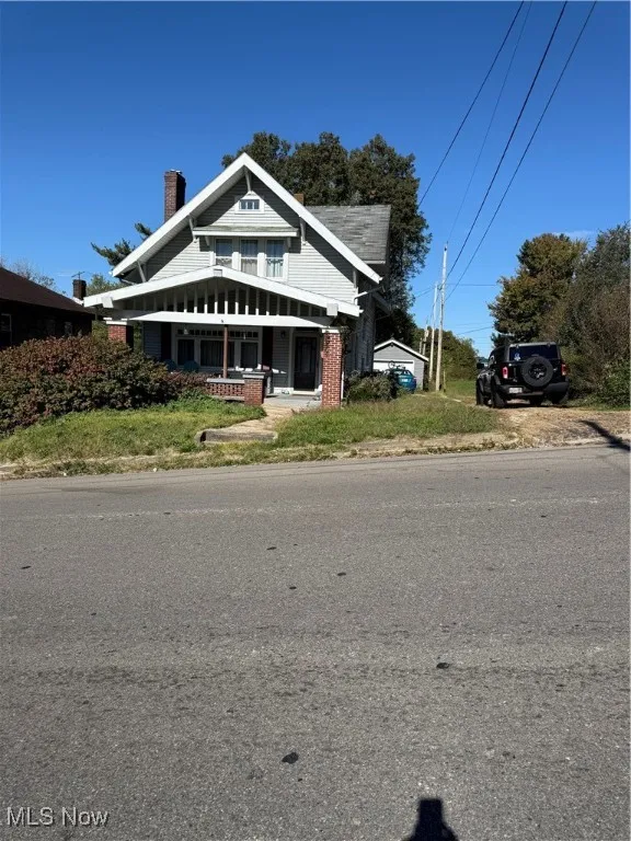 Bungalow-style house featuring a porch and a chimney