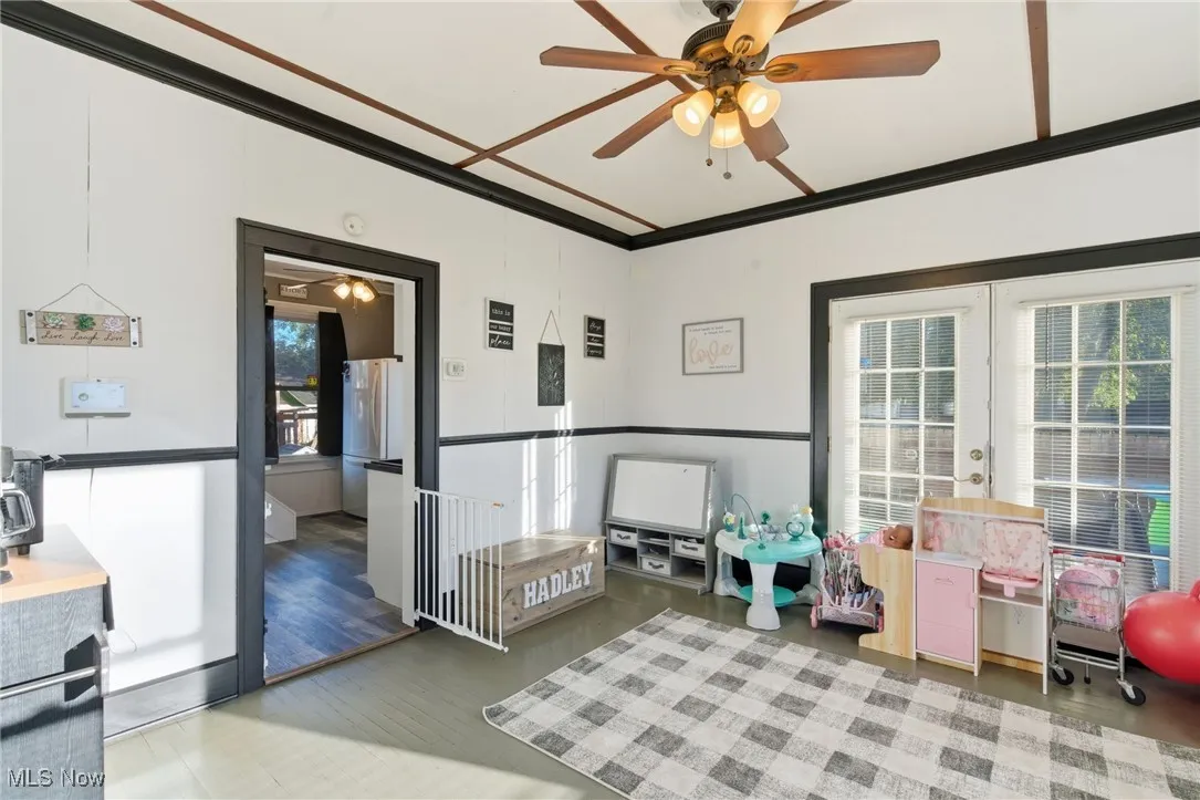 Playroom featuring crown molding, a ceiling fan, and light wood-type flooring