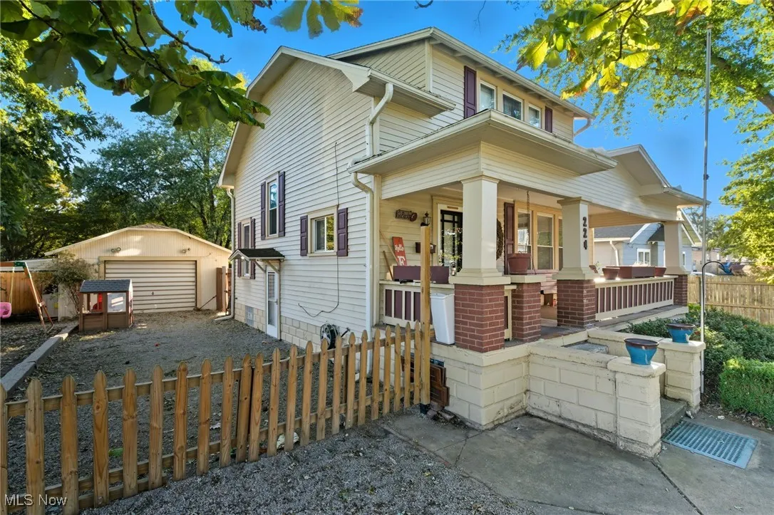 View of front of house featuring an outdoor structure, covered porch, and a detached garage