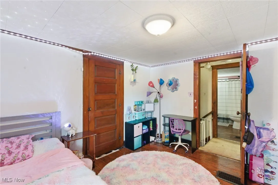 Bedroom with dark wood-style floors and ensuite bathroom