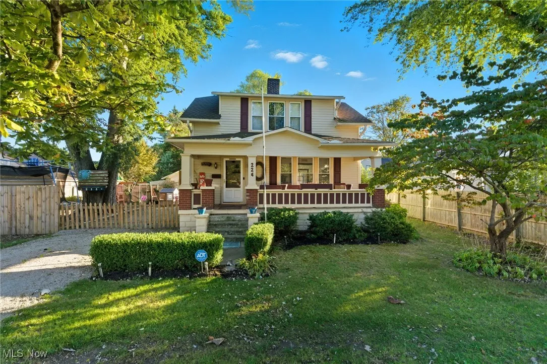 View of front facade featuring a porch, a chimney, and brick siding