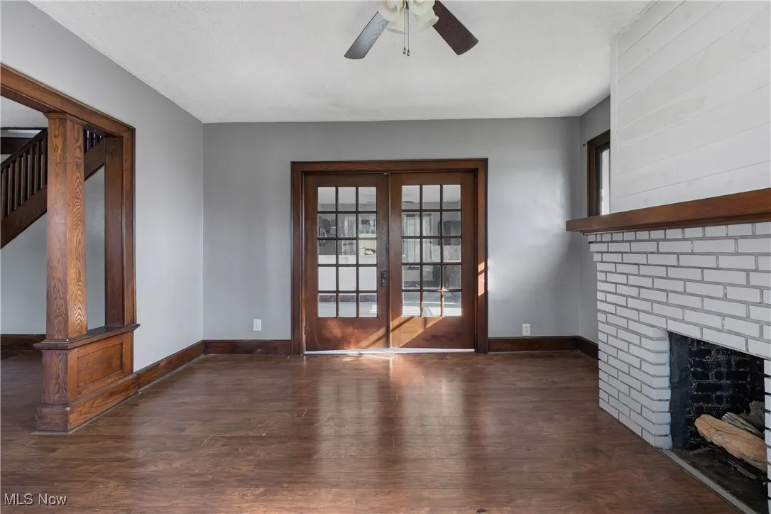 Unfurnished living room with dark wood finished floors, healthy amount of natural light, french doors, ceiling fan, and a textured ceiling