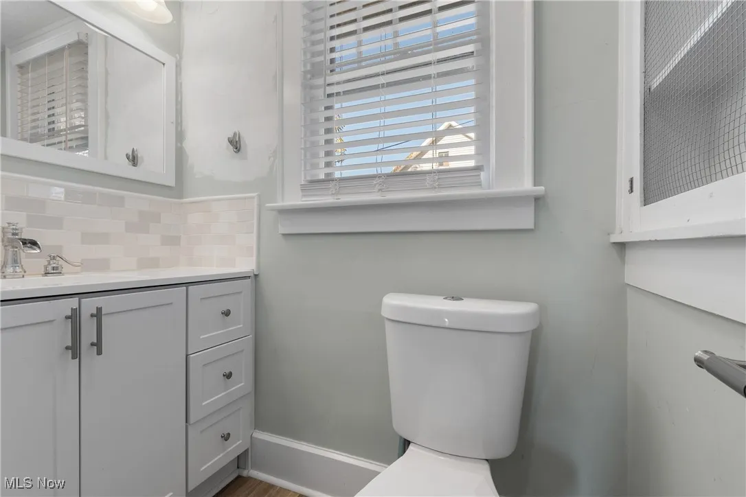 Bathroom featuring vanity and decorative backsplash