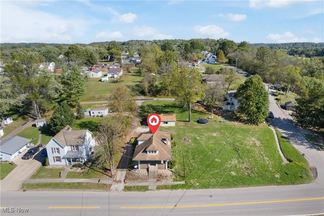 Aerial view of property and surrounding area featuring nearby suburban area