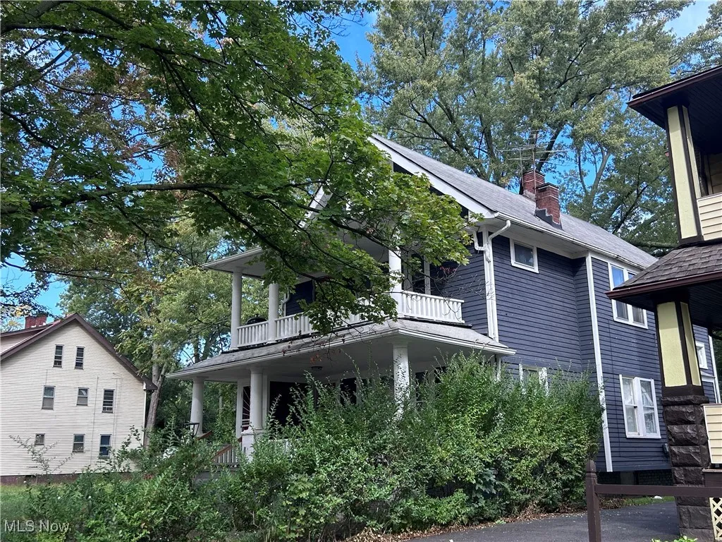 View of property exterior with a chimney, a balcony, and roof with shingles