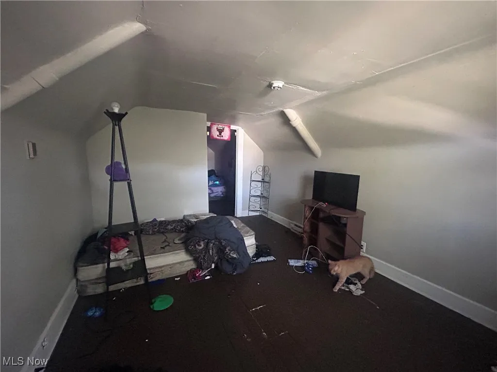 Bedroom with baseboards and lofted ceiling