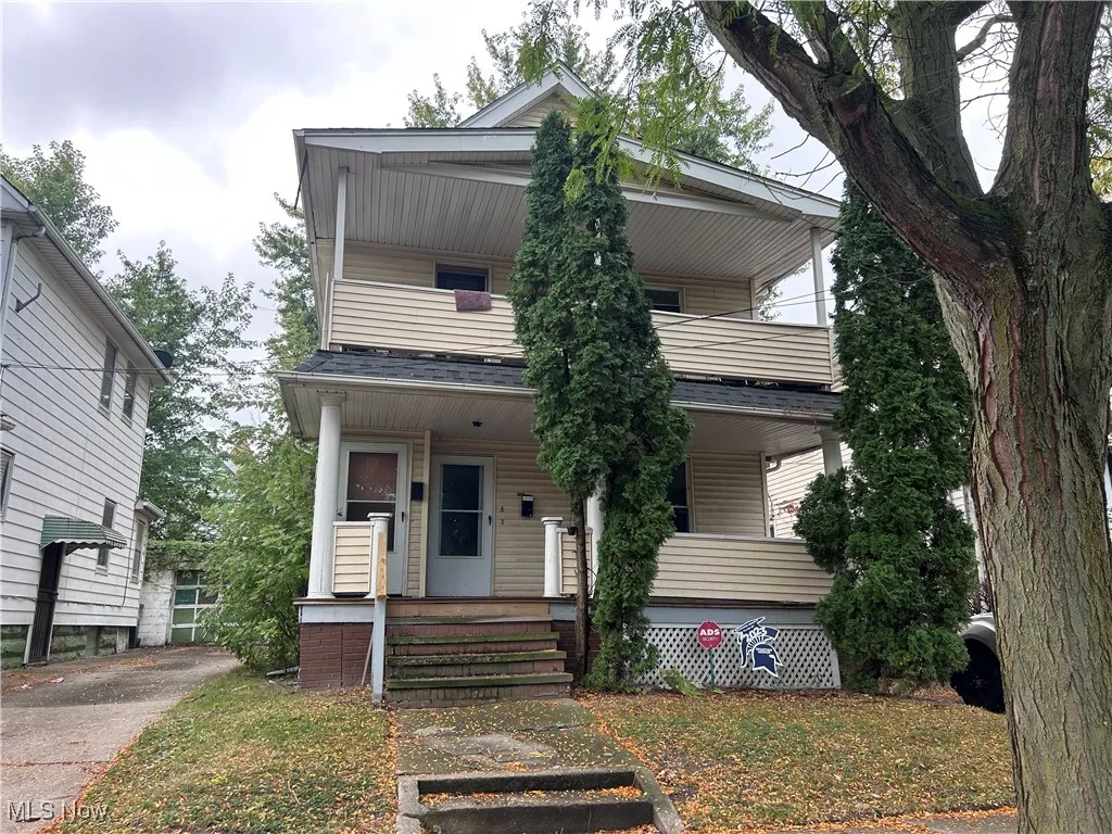 View of front of property with covered porch and a balcony