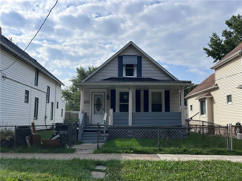 Bungalow with covered porch and a fenced front yard
